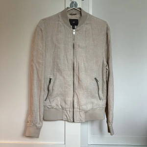 Jacka från H&M i linne - Oanvänd jacka i beige/natur linne från H&M. Väldigt fin vår- och sommarjacka i skick 10/10. 