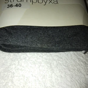 HELT NYA OANVÄNDA mörkgrå täckande strumpbyxor 36-40, Åhléns  - Helt nya oanvända mörkgrå täckande strumpbyxor i storlek 36-40 (Skulle dock säga passar någon med XS-S), från Åhléns. De är helt enfärgade och har en mjuk, stretchig känsla som gör dem bekväma att bära. Perfekta för att komplettera din outfit med en stilren look. Felfria.