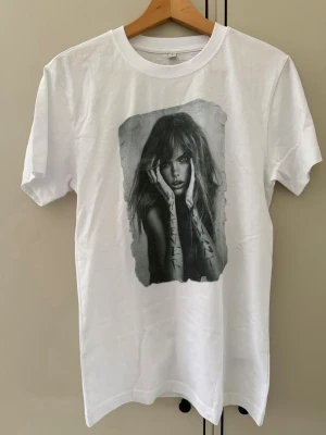 Vit t-shirt med tryck från mister Tee - Vit t-shirt från Motive i bomull med ett stort svartvitt tryck framtill som föreställer en person. Klassisk passform och rund halsringning. Perfekt för dig som gillar unika prints och streetstyle.