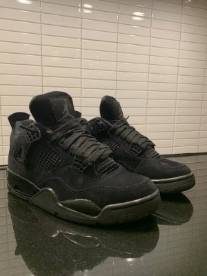 Svarta Air Jordan 4 Retro sneakers - Säljer ett par helsvarta Air Jordan 4 Retro black cat. Storlek 42. Är lite skadade på nätet men ingen man märker när man har på sig dom samt lite skav på dom men annars i bra skick 