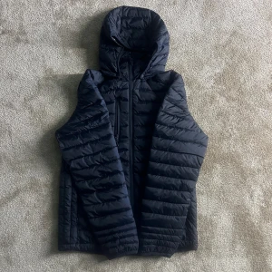 Mörkblå pufferjacka  - Säljer denna feta vinterjacka med en huva som går att ta av. Passar dig som är från 175 cm till 185. Den passade inte mig när jag köpte den så det är därför jag säljer den. Den har aldrig används och är i nyskick. Den är perfekt för vinter och nypriset är 1200 kr. Priset kan diskuteras.