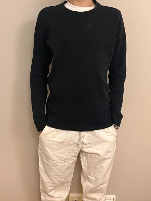 Svart långärmad tröja basic - Hej, säljer en enkel svart långärmad tröja med rund halsringning. Tröjan har en smal passform och är tillverkad i ett mjukt, ribbat material som ger en skön känsla. Perfekt att matcha med jeans eller chinos för en clean look. Tröjan är från Kappahl och är i storlek 158/164. Pris kan diskuteras