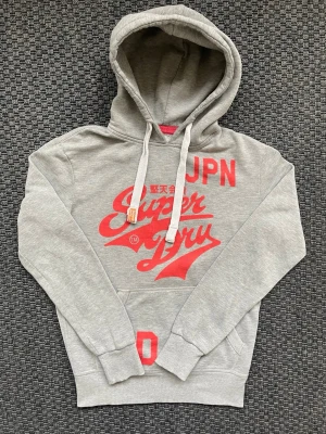 Vintage 2000s SuperDry hoodie JPN (Limited edition) - Säljer nu denna sjukt snygga och sällsynta vintage 2000s hoodie från Superdry! Perfekt passform och en både unik och stilren färg😊 Säljs ej längre i butik och är ur en limiterad upplaga och hoodien är därav mycket eftertraktad 🤩Storlek S och passar true to size 🙌Skriv vid funderingar🤝