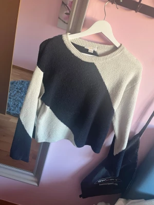 Svartvit stickad tröja med blockmönster - Säljer en snygg stickad tröja i svart och vitt med coolt blockmönster. Tröjan har rund halsringning och långa ärmar. Perfekt för dig som gillar en stilren men ändå unik look.