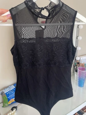 Svart spetsbody - Svart spetsbody som passar xs/s! Snygga detaljer och passar perfekt till finare tillfällen. Helt ny aldrig använts!