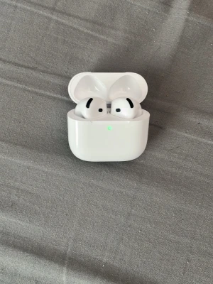 Apple AirPods 4 ANC - Säljer ett par vita Apple AirPods 4 med Active Noise Cancellation och laddningsetui. Snygg och kompakt design med in-ear passform och touchkontroller. Levereras med originalförpackning och tillbehör. Perfekta för musik, samtal och träning.