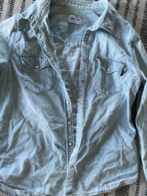 Ljusblå skjorta - Ljusblå skjorta med vita knappar