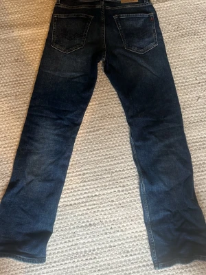 Mörkblå Replay Thad Jeans - Säljer ett par klassiska mörkblå jeans från Replay med raka ben och femficksmodell. Perfekta till en avslappnad stil och tillverkade i slitstark denim.