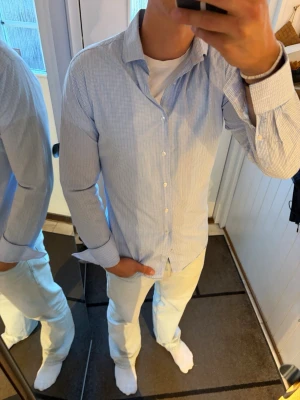 Rutig skjorta från The Shirt Factory - Riktigt snygg blå/vit rutig skjorta från The Shirt Factory. Skjortan är som ny och har inga skador. Storlek 39.