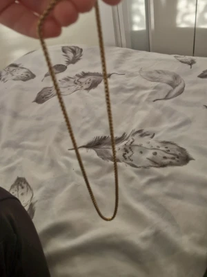 Guldtonat kedjehalsband - Snyggt halsband i guldtonad metall med klassisk kedjedesign. Halsbandet har en enkel och stilren look som passar till många olika outfits. Perfekt för dig som gillar minimalistiska accessoarer med en touch av vintage.