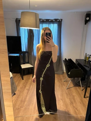 Balklänning Hilary Morgan - Brun vintage balklänning med gröna detaljer i gott skick. Kommer med axelband och grön scarf som är avtagbara.