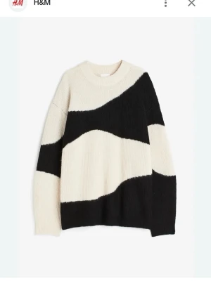 Beige och svart stickad tröja H&M - Snygg stickad tröja från H&M i beige och svart med vågiga blockmönster. Tröjan har rund halsringning, avslappnad passform och långa ärmar. Perfekt för dig som gillar trendiga och bekväma plagg. Materialet är mjukt och skönt.