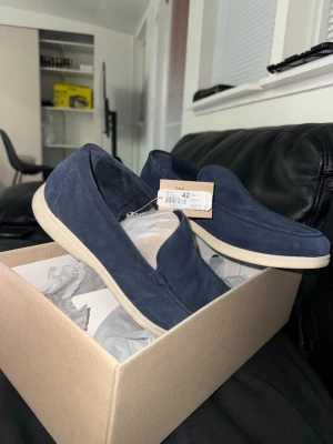 Marinblå mocka loafers - Snygga marinblå loafers i mocka med ljus sula. Skorna har en klassisk, stilren design utan snörning och passar perfekt till både jeans och chinos. Köptes inför ett bröllop och har endast använts engång och därför säljs billigare. Kvitto finns på köpet från 10 April ordinariepris 799kr. 