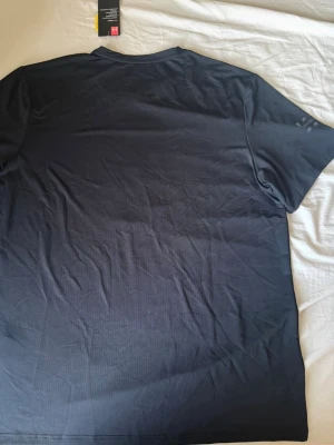 Svart Under Armour T-shirt - Ny,  Oanvänd,  Taggen sitter kvar.  Står storlek XXXL men den passar som M-L.  Alltså är storleken M-L och jag kan ge garanti att ifall den inte passar så kan man skicka tillbaka den.