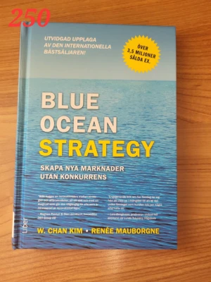 Blue Ocean Strategy bok - Säljer boken 'Blue Ocean Strategy' av W. Chan Kim och Renée Mauborgne. Boken har ett blått omslag med havsmotiv och tydlig gul och vit text. Perfekt för dig som vill lära dig om att skapa nya marknader utan konkurrens.