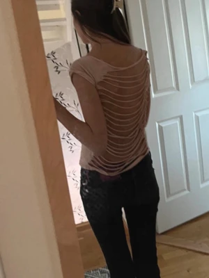 Ljusrosa topp med öppen rygg - Säljer en ljusrosa topp med offshoulder-design och korta ärmar. Baksidan har coola utskurna detaljer som ger en edgy look. Perfekt för dig som vill sticka ut lite extra. Materialet känns mjukt och lätt, som jag har gjort själv.