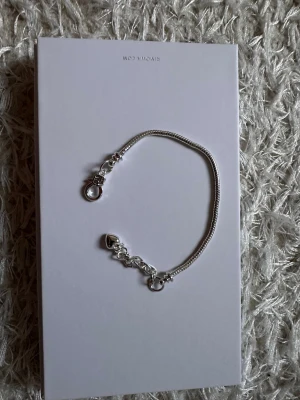 Tunt silverfärgat armband - Snyggt och stilrent armband i silverfärg med tunn kedja och dekorativa detaljer vid låset. Perfekt för dig som gillar minimalistiska accessoarer och vill ha något som funkar till många olika looks. Lätt att matcha med andra smycken.