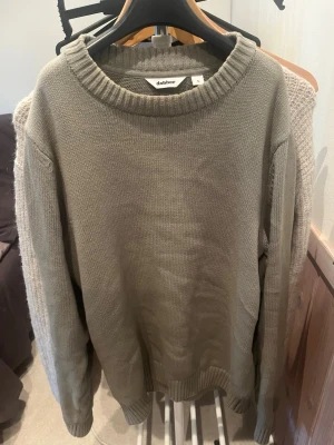 Olivgrön stickad tröja Dobber S - Säljer en olivgrön stickad tröja från Dobber i storlek S. Tröjan har rund halsringning med bred ribbstickad kant och långa ärmar. Enkel och stilren design som passar perfekt till lager-på-lager. Materialet känns mjukt och bekvämt.