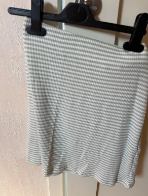 Grönvitrutig kortkjol från Nelly  - Säljer en söt kortkjol med grönvitt rutigt mönster. Kjolen har en enkel och rak passform, perfekt för dig som gillar en clean och stilren look. Materialet känns mjukt och bekvämt, passar perfekt till både sneakers och boots.