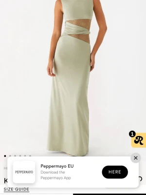 Ljusgrön långklänning från Peppermayo - Helt ny trendig ljusgrön långklänning från Peppermayo med ärmlös design och coola meshdetaljer i midjan. Klänningen har omlottband över magen och en stilren, figurnära passform. Perfekt för dig som vill sticka ut med en unik look.