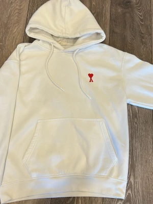 Ami hoodie - En vit ami p@ris hoodie i nästan perfekt skick, jag har använt den 3 gånger men tyckte den var för stor. Den är storlek M och jag är 170, 57kg. Perfekt hoodie nu inför sommarn på kvällarna. Perfekt kvalité, materialet är så bra det blir. Om du är runt 175-185 passar din nog dig perfekt beroende på hur du vill att den sitter.