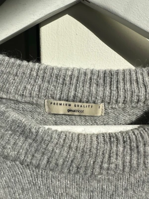 Grå stickad tröja från Gina Tricot - Mysig grå stickad tröja från Gina Tricot med rund halsringning och ribbade muddar. Tröjan har en relaxed passform och är perfekt för lager på lager. Tillverkad i mjukt material som känns skönt mot huden. I Gina premium quality 