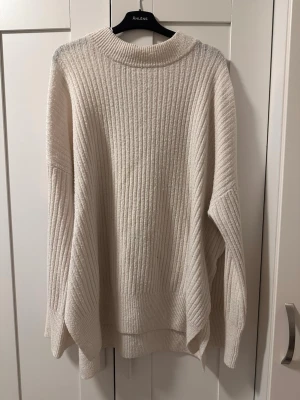 Oversized cremevit stickad tröja - Säljer en oversized stickad tröja i cremevitt. Tröjan har bred ribbstickning, rund halsringning och långa ärmar med droppad axel. Perfekt för lager på lager och riktigt mysig till hösten och vintern.