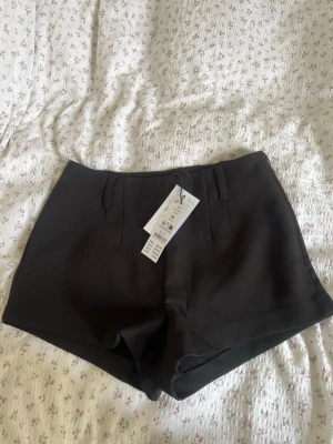 Svarta kostym shorts  - Säljer ett par svarta kostym mini shorts från Gina Tricot, helt nya och oanvända. Storlek 36. 