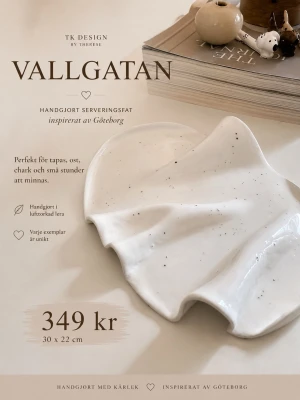 Handgjort serveringsfat Vallgatan - Unikt handgjort serveringsfat inspirerat av Göteborg, tillverkat i vit lufttorkad lera med svarta prickar. Fatet har en organisk, vågig form och mäter 30 x 22 cm. Perfekt för tapas, ost och chark. Varje exemplar är unikt.