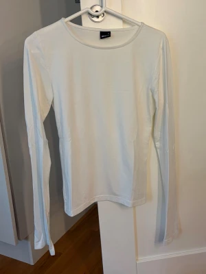 Långärmad vit topp från Gina tricot med slit - Super fin långärmad topp från Gina tricot med slit nertill armarna 