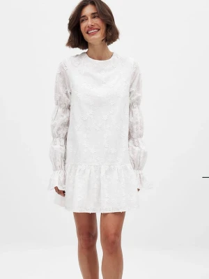 Vit kort klänning med spetsdetaljer - Supersöt vit kortklänning med blommig spets, volangkant och långa puffärmar. Klänningen har öppen rygg med knytband och en avslappnad passform. Perfekt för studenten och sommarens alla tillfällen! Pris kan diskuteras