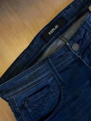Replay anbass - Snygga mörkblå jeans från Replay med klassisk femficksmodell och raka ben. Jeansen har tydliga sömmar och en patch med Replay-logga bak i midjan. Tillverkade i slitstarkt denimtyg som ger en tidlös look.
