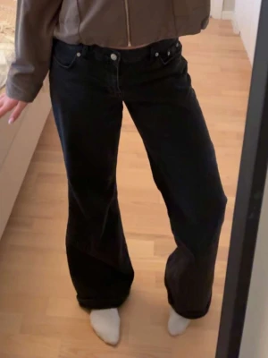 Svarta vida jeans med låg midja - Säljer ett par svarta jeans med låg midja och raka, vida ben från Nakd
