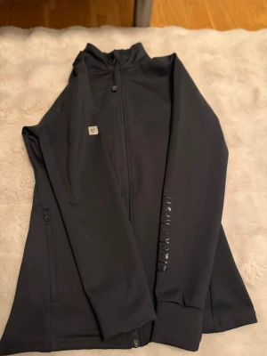 Svart jacka från Black Heart - Snygg svart jacka från Black Heart med hög krage och dragkedja framtill. Jackan har diskret logga på bröstet och texten 'black heart' i blankt tryck längs ena ärmen. Perfekt för dig som gillar stilrena plagg med en twist. Sjukt snygg både till vardags å på tävling i stallet💗storlek M men upplevs som S/XS 💞