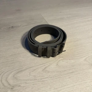 Grått bälte i mocka - Snyggt och stilrent grått bälte i mocka med ett klassiskt metallspänne. Perfekt för att lyfta vilken outfit som helst och passar till både jeans och kostymbyxor. Säljer fler bälten så vid intresse av fler kan paketpris göras:)