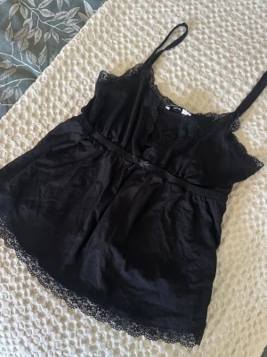 Topp - Söt svart topp från Nelly i storlek XS. Är i mycket fint skick!🤩
