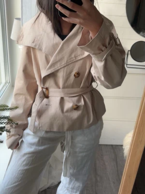 Trench med knyt - En supercool kort trenchcoat med knyt detalj från meet me there🍋🌊🤍(använd ca 1 gång)
