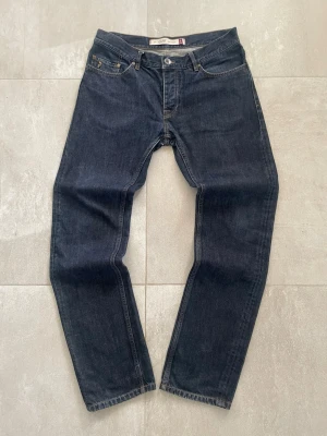 Peak performance Åre SwedenMörkblå jeans från 1986 - Snygga mörkblå jeans från märket 1986 med klassisk femficksdesign och raka ben. Jeansen har kontrastsömmar och metallknapp i midjan. Perfekta för dig som gillar en tidlös och enkel stil.