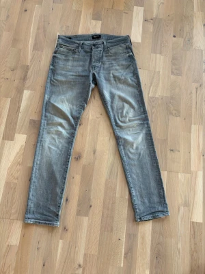 Jack&Jones grå slim/Glenn - Säljer ett par grå slim fit jeans.  Använda väldigt sällan. Väldigt bra skick. Lite lösare än slim fit. Skriv om ni har frågor!!! Pris ej hugget i sten.