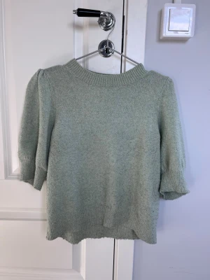Grön stickad tröja  - Jättefin stickad T-shirt, använd men inga större tecken på det förutom att den är något nopprig men inget man tänker på. Storlek xs men passar även som en S.
