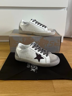 Golden Goose sneakers dam - Golden Goose sneakers – stl 38  Säljer ett par Golden Goose i mycket fint skick. Endast använda vid något enstaka tillfälle, så de är i princip som nya.  Skorna tillhör min tjej som köpte dem via Vinted med verifiering, men storleken passade tyvärr inte – därför säljs de vidare.  Storlek: 38 Skick: Nästan nyskick Nypris: (7000) Pris: (2899) Hör av dig vid frågor eller om du vill ha fler bilder