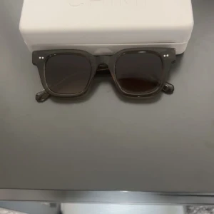 Gröna CHIMI 04,  - Stilrena gröna solglasögon från CHIMI med fyrkantig form och mörka glas. Klassisk design med diskreta silvriga detaljer vid bågarna. Kommer med originaletui. Perfekta för dig som gillar en trendig och tidlös look.