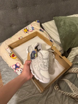 Asic gel nyc cloud gray - Snygga vita sneakers från Asics med mesh och syntetdetaljer. Skorna har en chunky sula och klassisk snörning. Perfekta för dig som gillar en clean och sportig stil. Diskret Asics-logga på sidan och tungan.