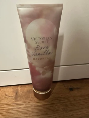 Victoria's Secret Bare Vanilla Daydream - Body lotion från Victoria's Secret i doften Bare Vanilla Daydream. Tuben är i mjuka pastellfärger med moln och guldiga detaljer. Innehåller noter av fluffig vanilj och mjuk sandelträ. Perfekt för dig som gillar söta och varma dofter. Aldrig använts. 
