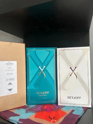 Xerjoff Erba Pura Eau de Parfum - Lyxig parfym från Xerjoff, Erba Pura, i en elegant turkos flaska med gulddetaljer och matchande förpackning. Flaskan har en unik, kantig form och levereras i en exklusiv box med färgstark insida. Perfekt för dig som gillar exklusiva dofter.