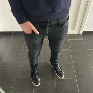 Svarta Dondup George - Säljer ett par svarta dondup george jeans med lätt tvättad look och klassisk femficksmodell. Jeansen har normal midja och smala ben, perfekta till sneakers och hoodie. Materialet känns mjukt och stretchigt för extra komfort.