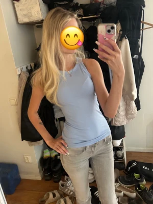 Ljusblå ribbad linnetopp - Säljer en ljusblå ribbad linnetopp med tight passform och rund halsringning. Toppen är ärmlös och har en enkel, stilren design som passar perfekt till jeans eller kjol. Perfekt för varma dagar eller som lager under en skjorta. Från AMISU i storlek XS. 