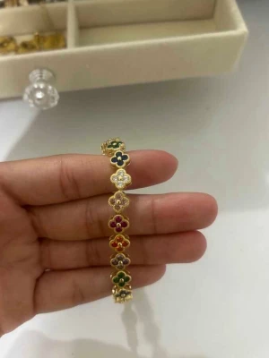 armband med blommor - Armband i guldton med flera små blommor i olika färger. armbandet har en elegant och lekfull design. Perfekt accessoar för att lyfta din outfit💖