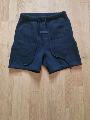 Essentials shorts - Svarta shorts i mjukt material med elastisk midja och snörning framtill. Perfekta för en avslappnad stil och passar till många olika outfits. Klassisk och enkel design utan synliga loggor eller mönster.