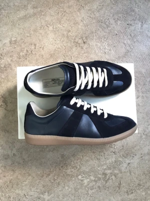 Maison margiela gats - As snygga maison margilea skor i färgen navy. De kanske inte syns på bilderna men de är en djup mörk navy färg i person som ger en lyxig känsla. Skorna är använda endast två gånger och har några creases, fortfarande i jättebra skick. priset går att diskutera!